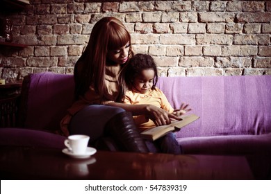Mother and her daughter reading a book. 