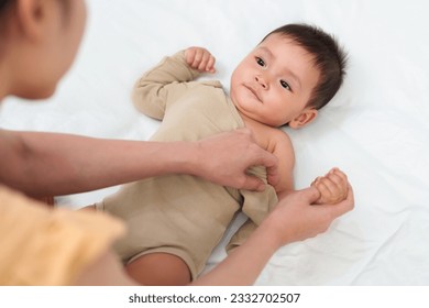 mother with her infant baby during changing the clothes - Powered by Shutterstock