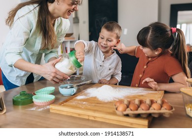 Mother With Her Kids Baking Together In Their Home