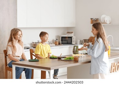 Mother with her little children making toasts in kitchen - Powered by Shutterstock