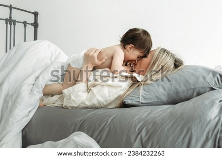 Similar – Little girl playing over boy lying in the bed