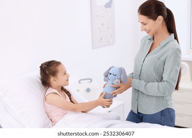 Mother and her little daughter on bed in hospital - Powered by Shutterstock