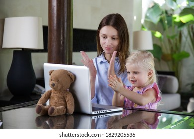 Mother And Her Little Toddler Girl Sitting In Front Of Laptop, Listening To Music And Clapping Hands.	