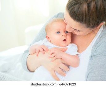 Mother and her Newborn Baby together. Love. Happy Mother and Baby kissing and hugging. Photo of Beautiful Family. Maternity concept. Parenthood. Motherhood - Shutterstock ID 644391823