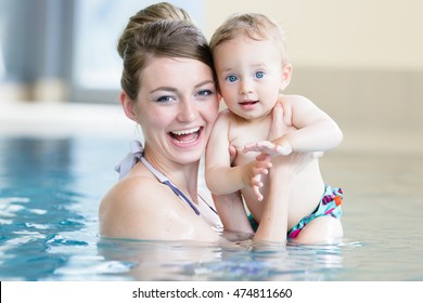 Mother and her newborn child at infant swimming class