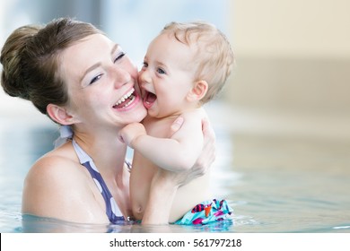 Mother and her newborn child at infant swimming class