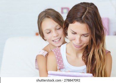 Mother With Her Preteen Daugher Playing Ipad Together