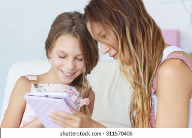 Mother With Her Preteen Daugher Playing Ipad Together