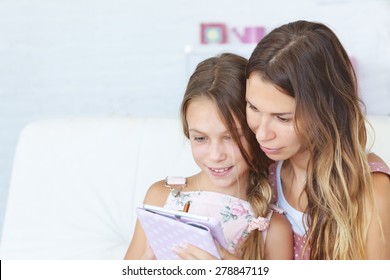 Mother With Her Preteen Daughter Playing Ipad Together