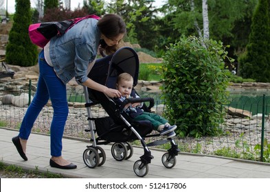 Mother with her small baby bo are walking in the park