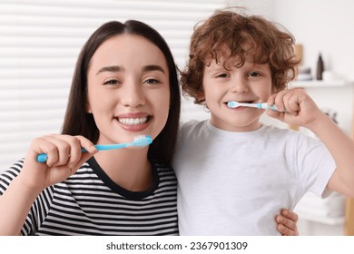 Mother and her son brushing teeth together in bathroom - Powered by Shutterstock