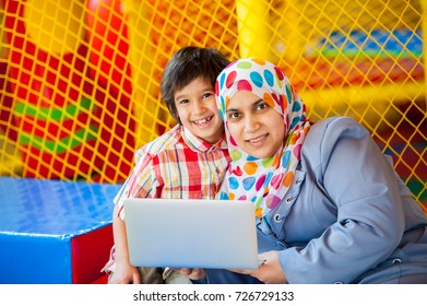 Mother And Her Son Laptop In Bouncy Room