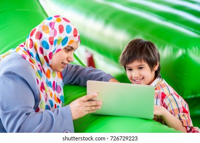 Mother And Her Son Laptop In Bouncy Room