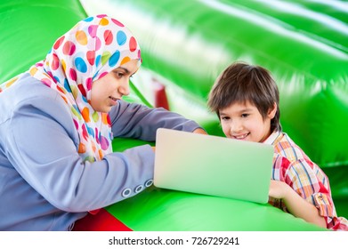 Mother And Her Son Laptop In Bouncy Room