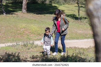 Mother with her son walking in the countryside while looking for caches