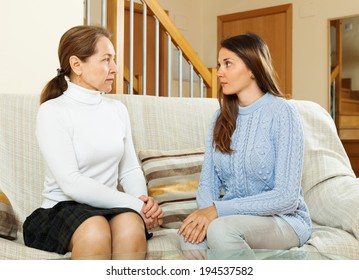 Mother With Her Teen Daughter Having Serious Talking At Table In Living Room