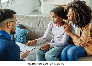 Mother with her teenage daughter at meeting with social worker, psychologist discussing mental health family sitting on sofa in psychotherapist office - Powered by Shutterstock