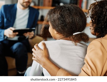 Mother with her teenage daughter at meeting with social worker, psychologist discussing mental health family sitting on sofa in psychotherapist office - Powered by Shutterstock