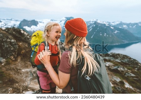 Mother hiking with daughter in Norway mountains travel together family time healthy lifestyle active vacations woman playing with child Mother's day holiday