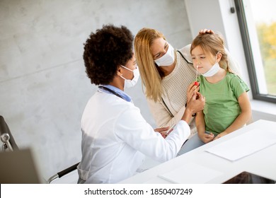 Mother With His Little Daughter At The Covid PCR Test By African American Female Doctor