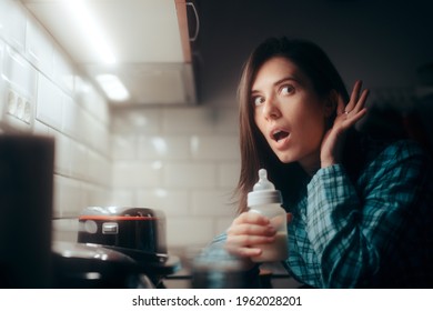 Mother Holding A Baby Bottle Hearing Her Baby Cry At Night. Attentive Mom Preparing Formula For Night Feeding Hungry Newborn Child
