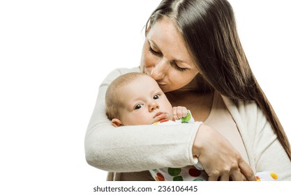 Mother Holding A Baby In Her Arms And Kissing It Tenderly Isolated On White Background