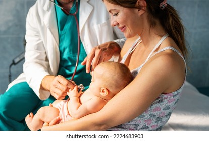 Mother Holding Baby For Pediatrician Doctor To Examine