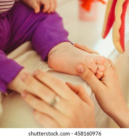 Mother holding baby's feet - Shutterstock ID 458160976