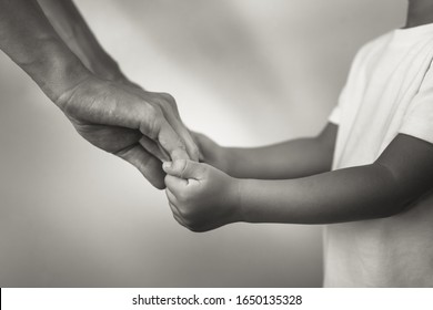 Mother holding child's hand. In studio shot.  - Powered by Shutterstock