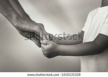 Mother holding child's hand. In studio shot. 