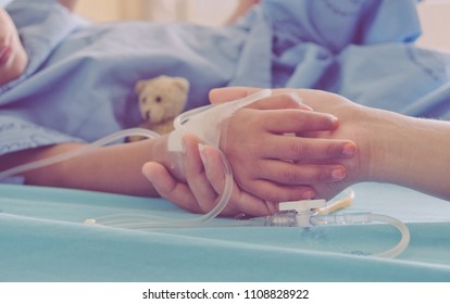 Mother holding child's hand who fever patients in hospital to give encouragement. - Powered by Shutterstock