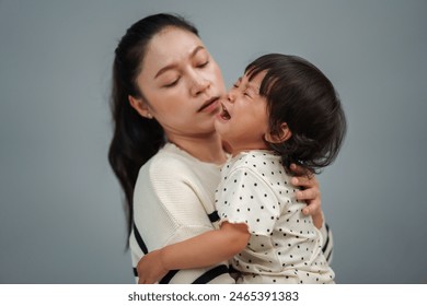 mother holding and comforting her crying toddler baby  - Powered by Shutterstock