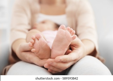 Mother Holding Cute Baby On Her Knees, Closeup