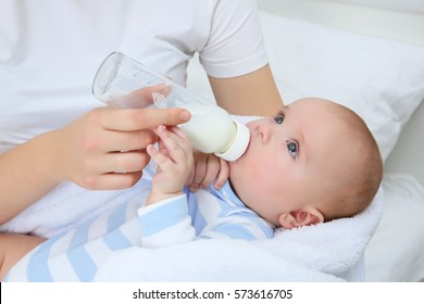 Mother Holding And Feeding Baby From Bottle