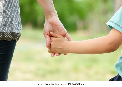 Mother holding a hand of her son