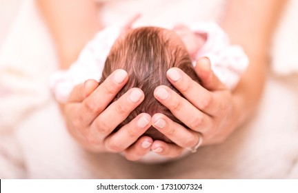 Mother Holding Head Of Her Newborn Girl In Hands. The Baby On Hands At Mum. Family Concept. Loving Mother Hand Holding Cute Sleeping Newborn Baby Child.