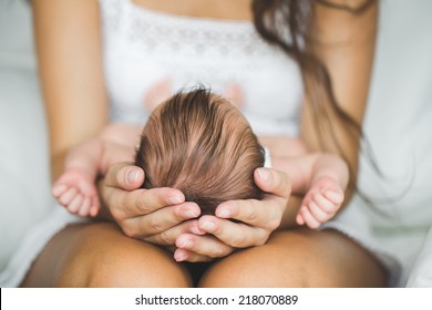 Mother Holding Head Of Her Newborn Son In Hands. The Baby On Hands At Mum. Loving Mother Hand Holding Cute Sleeping Newborn Baby Child