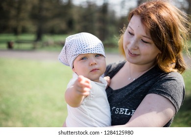 Mother Holding Her Baby Daughter On A Sunny Spring Day. High Key Lifestyle Image, Shallow Depth Of Field.