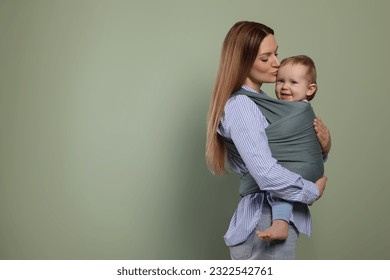 Mother holding her child in baby wrap on olive background. Space for text - Powered by Shutterstock