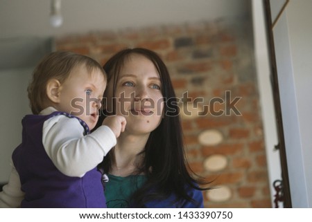 Mother holding her child and staring into window, with copyspace