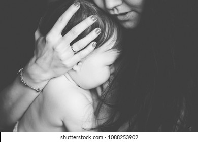 Mother holding her crying little baby. black and white photo. pain with teething