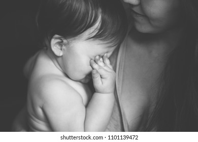 Mother Holding Her Crying Little Baby. Black And White Photo. Pain With Teething