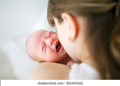 Mother holding her crying little son in studio - Shutterstock ID 301455563
