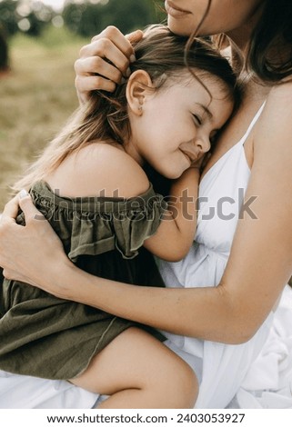 Mother holding her little daughter in arms, comforting and stoking her head, outdoors. Foto stock © 