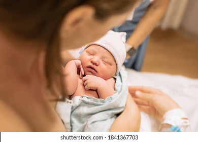 Mother holding her newborn baby girl in her arms moments after birth.  - Shutterstock ID 1841367703