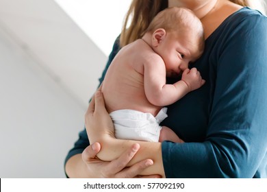 Mother Holding Her Newborn Baby Daughter After Birth On Arms. Mum With Baby Girl, Love. New Born Child Cuddling In Mama Arms. Bonding, Family, New Life