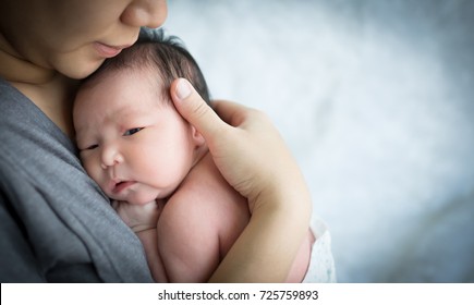 Mother holding her newborn baby daughter after birth on arms.,  Concept of love and family., Newborn baby girl., new life.
