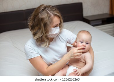 Mother Holding Her Sick Baby Boy Wearing A Medical Mask