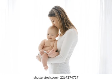 Mother, holding her sick baby boy, sad baby, isolated on white background  - Powered by Shutterstock