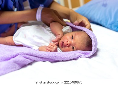 Mother Holding Infant Asian Baby Wrapped In Towel For Warm. Newborn And Mother Care Concept.